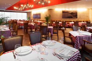 a restaurant with tables and chairs with red and white tablecloths at Emporio Cancun - Buy All Inclusive Option in Cancún