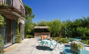 eine Terrasse mit einem Tisch und Stühlen im Hof in der Unterkunft Campagne les Jumeaux in Saint-Tropez