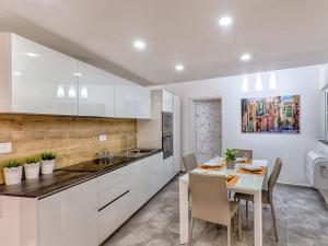 a kitchen and dining room with a table and chairs at Designer Finished Maisonette with Pool in Mellieħa