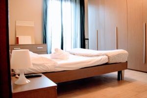 1 dormitorio con 2 camas y escritorio con lámpara en San Donato Apartments en Turín