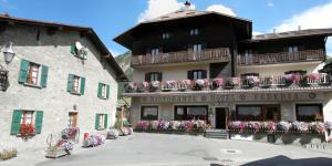 a building with flowers on the balconies of it at Hotel Federia in Livigno