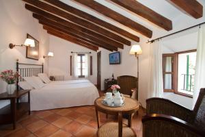 a bedroom with a bed and a table with flowers on it at Turismo de Interior S'Ardeviu in Sóller