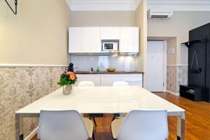 een keuken met een witte tafel en witte stoelen bij Markiz Luxury Apartments in Zagreb