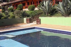 a swimming pool in front of a building at Hotel Pousada Boa Montanha in Monte Verde