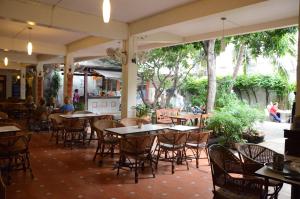 an empty patio with tables and chairs in a restaurant at Lamphuhouse Bangkok in Bangkok