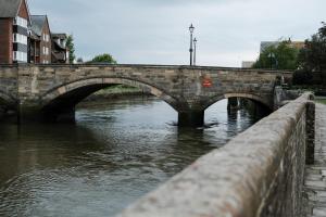 a stone bridge over a river in a city at Swan Hotel in Arundel