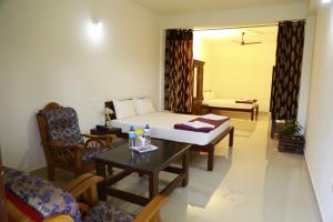 a room with a bed and a table and chairs at Skyrock Inn in Kattappana