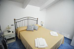 um quarto com uma cama grande com duas toalhas em A due passi dalla costiera em Agerola