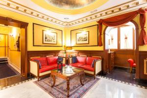 ローマにあるホテル マンフレディ スイート イン ローマのリビングルーム(赤いソファ、テーブル付)