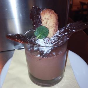 Rifugio Fermeda Hutte في سانتا كريستينا إن فال غاردينا: a drink sitting on a plate with a garnishment gmaxwell gmaxwell