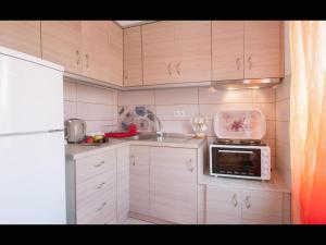 a small kitchen with white cabinets and a microwave at Evmorfias House in Kallirákhi