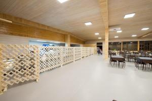 a large room with tables and chairs and wooden walls at Aquamarine Resort in Akshi