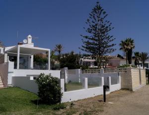 uma cerca branca em frente a uma casa com uma árvore de Natal em Beach-Front Bahia Dorada em Estepona