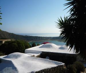 a group of snow covered buildings with a lake at Dammuso Il Fenicottero Rosa in Pantelleria