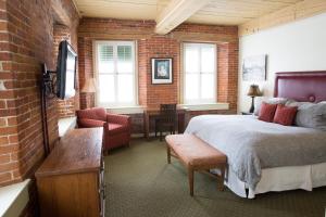 um quarto com uma cama e uma parede de tijolos em The Common Man Inn & Restaurant em Claremont