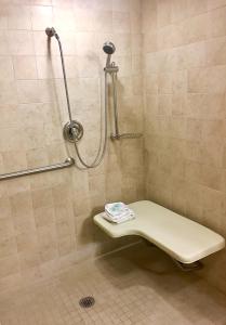 a shower with a bench in a bathroom at The Majestic Philadelphia Airport in Essington