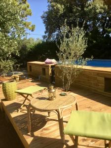 d'une terrasse avec une table et des chaises à côté de la piscine. dans l'établissement Longo Maï, à Sillans-la-Cascade