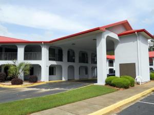 a large white building with a red roof at Country Hearth Inn & Suites Dawson in Dawson