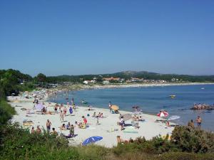 duża grupa ludzi na plaży w obiekcie Apartamentos Luis Antonio Mestre w mieście O Grove