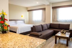- un salon avec un canapé et un lit dans l'établissement Crown Victoria Hotel, à Querétaro