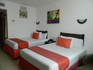 Habitación de hotel con 2 camas en naranja y blanco en Hotel Enriquez, en Coatzacoalcos