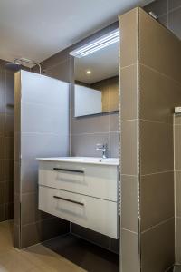 La salle de bains est pourvue d'un lavabo et d'un miroir. dans l'établissement Slapen aan de Bosweg, à Zoutelande