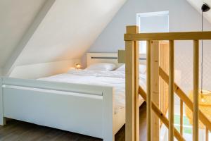 a bedroom with a bunk bed and a ladder at Slapen aan de Bosweg in Zoutelande