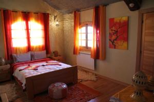 a bedroom with a bed and two windows at La pommeraie d'Ifrane in Ifrane