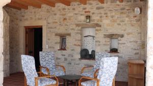 a room with chairs and a table and a stone wall at Eski Datça Otel in Datca