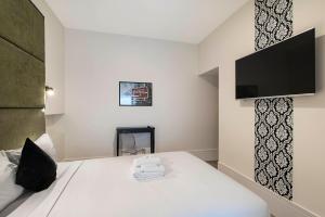 a bedroom with a bed with a tv on the wall at Sydney Boutique Hotel in Sydney