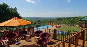 una terraza con sillas, una sombrilla y una piscina en Ratanakiri Paradise Hotel & Restaurant en Banlung