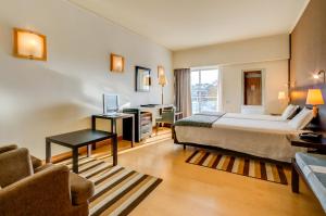 a hotel room with a bed and a desk at Hotel Alvorada in Estoril