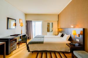 a hotel room with a bed and a desk at Hotel Alvorada in Estoril