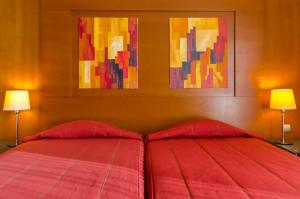 a bedroom with a red bed with two lamps at Hotel Alvorada in Estoril