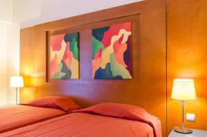 a bedroom with a bed and a painting on the wall at Hotel Alvorada in Estoril