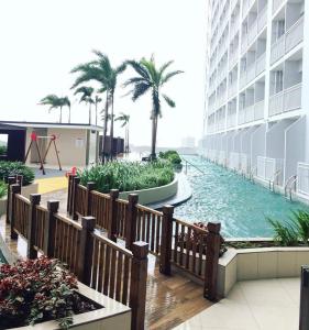 une piscine au milieu d'un immeuble avec des palmiers dans l'établissement Breeze Residences by CS Luxe, à Manille