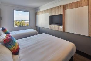 a bedroom with a bed and a television at ibis budget Sydney Airport in Sydney