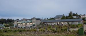 eine Reihe von Häusern auf einem Hügel mit Bäumen in der Unterkunft Hotel Lake Brunner in Moana