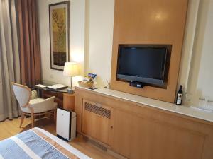 een hotelkamer met een flatscreen-tv op een dressoir bij Dia Park Premier in Gurgaon