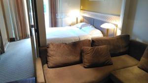 Habitación de hotel con cama y sofá en Flat no Hotel Mountain Village en Canela