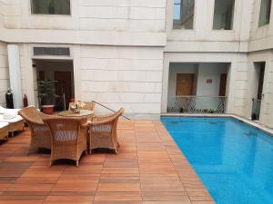 un patio con mesa y sillas junto a una piscina en Dia Park Premier en Gurgaon