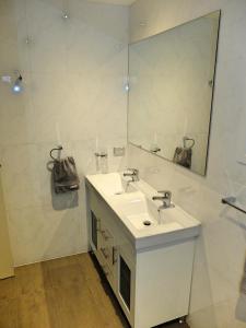 a white bathroom with a sink and a mirror at Rock Wallaby in Kingston 