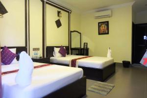 a hotel room with two beds and a mirror at VIBOLA Guesthouse in Kampot