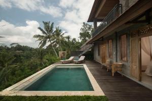 a swimming pool on a porch of a house at Villa Tepi in Ubud