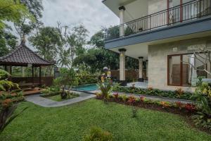 a house with a garden and a swimming pool at Puri Astina Villa in Ubud