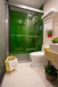 een badkamer met een toilet en een groene douche bij Vatica Anhui Hefei Maanshan Road Lvdiyinghai Zhugang Metro Hotel in Hefei