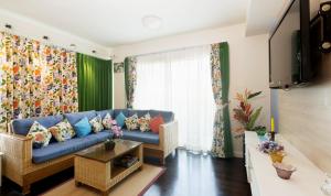 a living room with a blue couch and a window at Baan Sandao by Nanni in Hua Hin