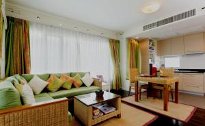 a living room with a green couch and a kitchen at Baan Sandao by Nanni in Hua Hin