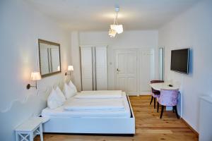 Schlafzimmer mit einem Bett, einem Schreibtisch und einem Tisch in der Unterkunft Madar Café Restaurant zum Fürsten in Melk