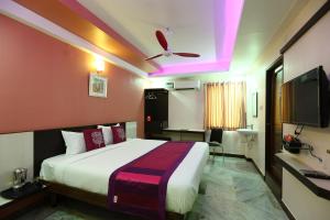 a hotel room with a bed and a ceiling fan at Hotel Lotus in Madurai
